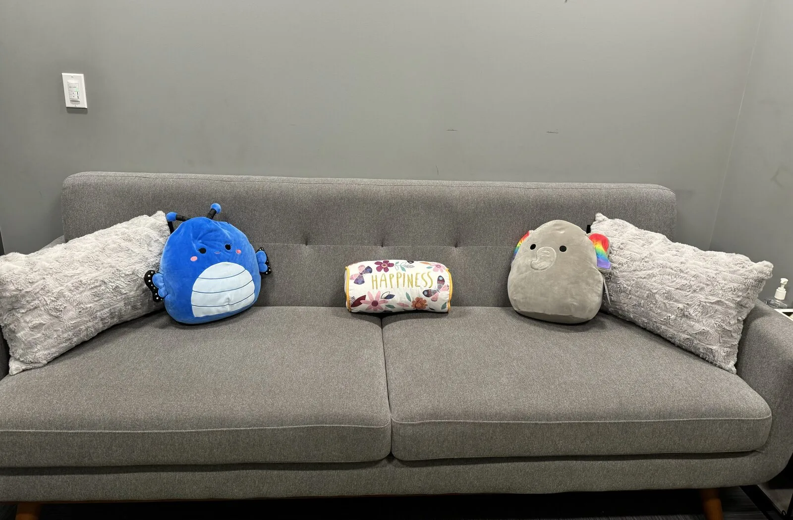 A cozy couch with soft cushions in a Flutterby Psychology therapy room